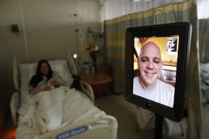 A doctor conducts a bedside consultation via the Double telepresence robot by Double Robotics